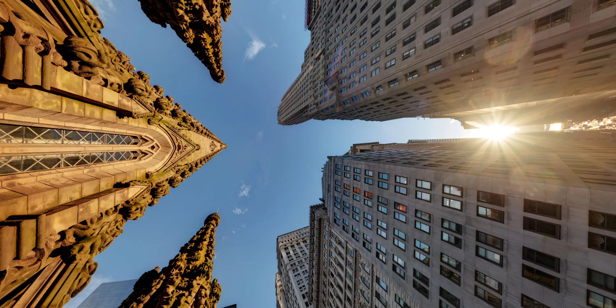 Sunrise in Downtown Manhattan, looking up to the top of Trinity's steeple and the tops of other buildings