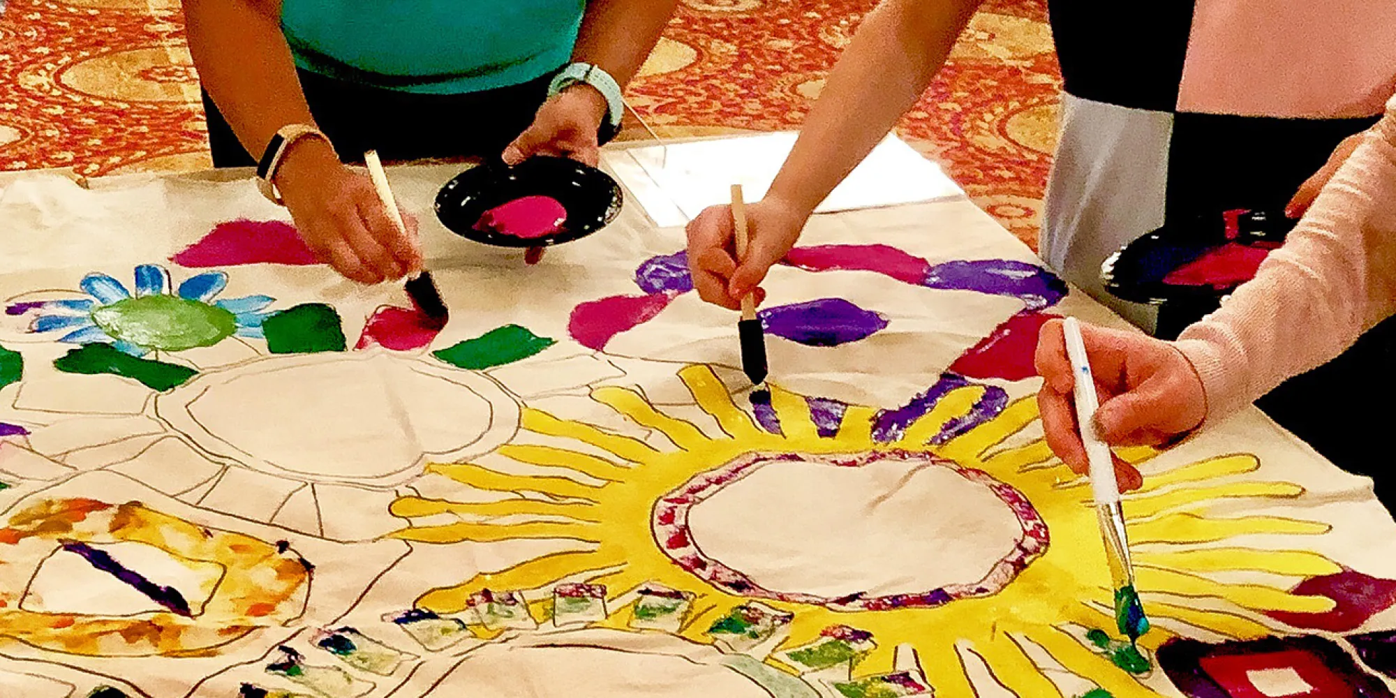 Hands painting a mural