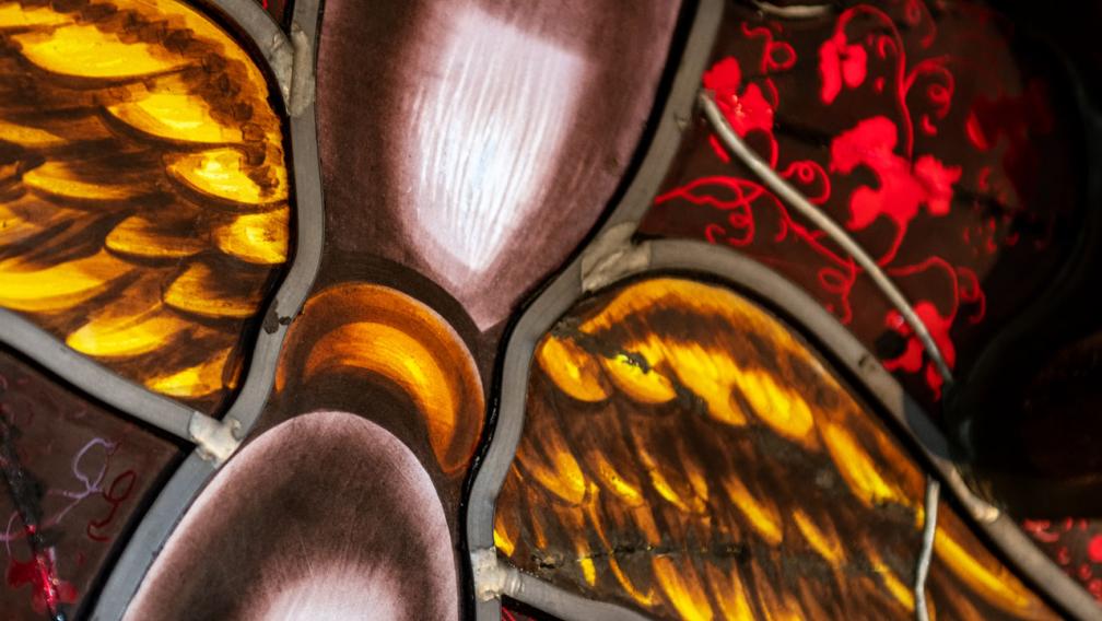 Stained glass image of an hourglass with wings