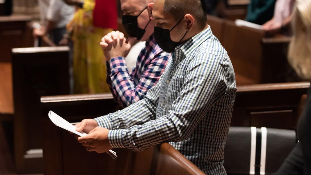 Worshippers kneeling in the pews of Trinity Church