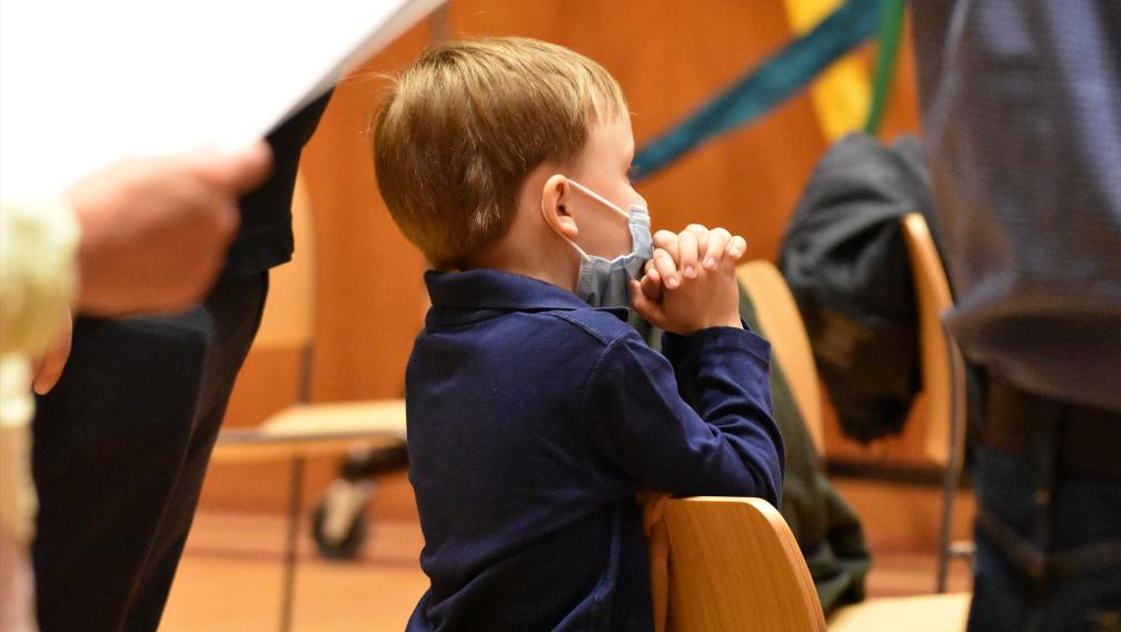 A child prays during Family Service in Parish Hall