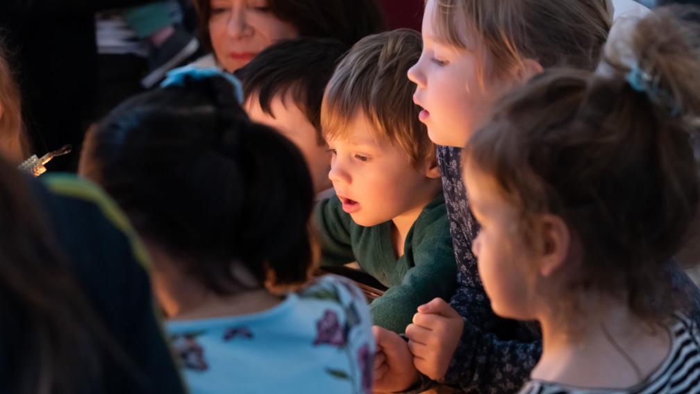 Children gather in glowing candlelight