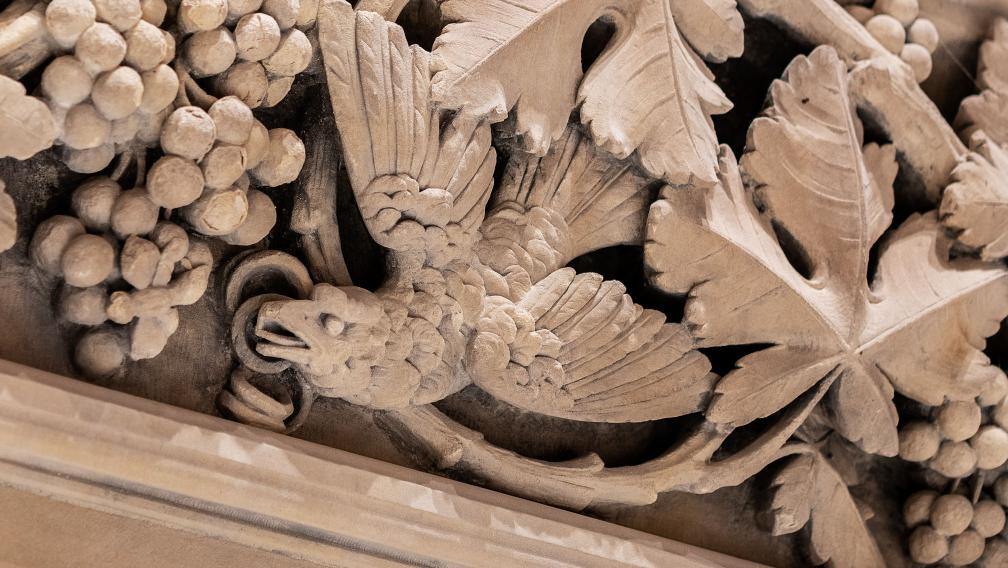 Detail photo of plaster work depicting a bird and foliage in Trinity Church