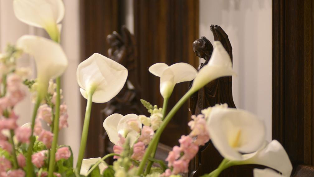 Easter lilies in Trinity Church in front of carved wooden angels