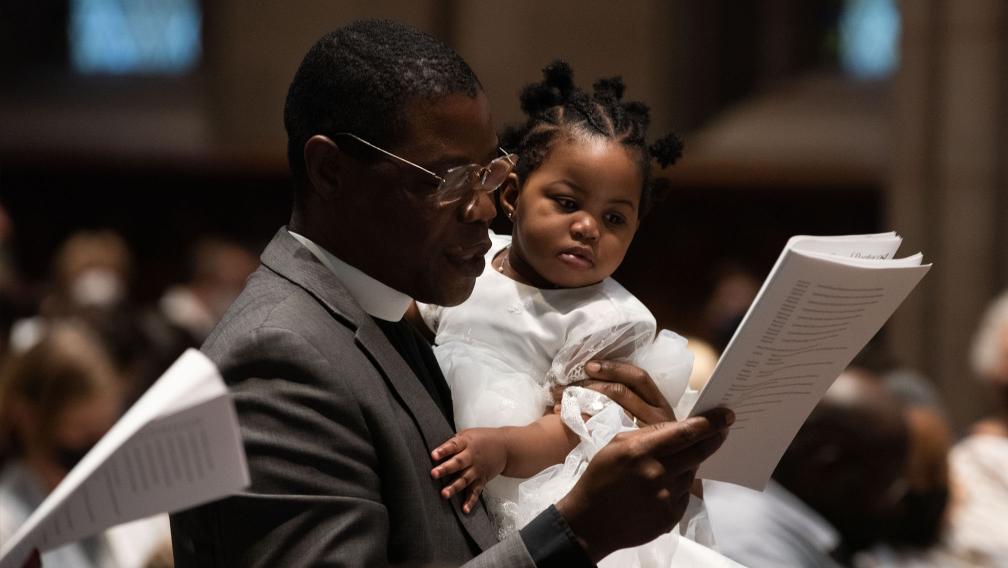 A man holds a child during Holy Eucharist at Trinity Church