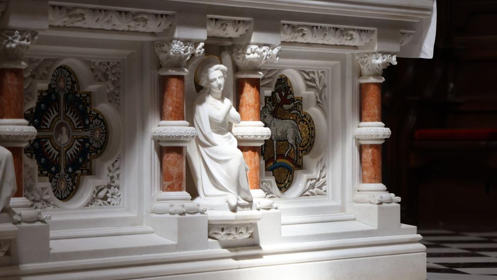 Light shines on the carving of a figure on the altar of Trinity Church