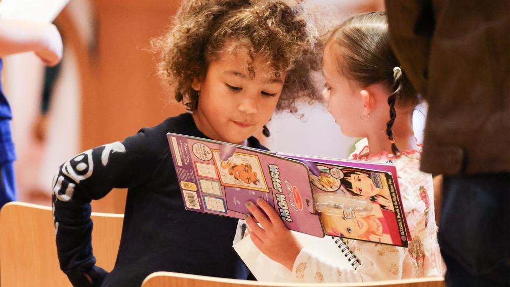 Two children look at an activity book during Family Service at Trinity Commons