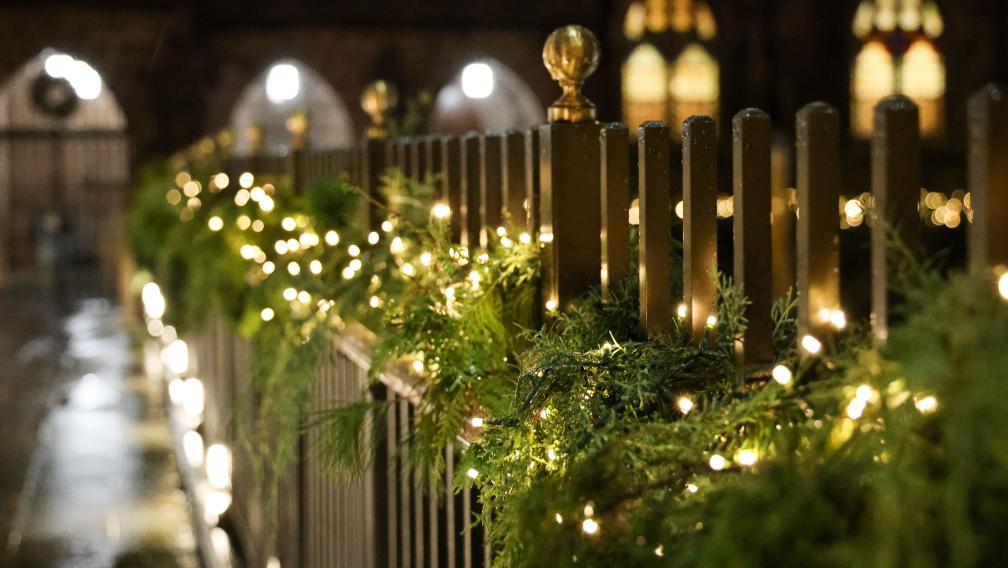 Lighted evergreen boughs line the pedestrian bridge in Trinity Church