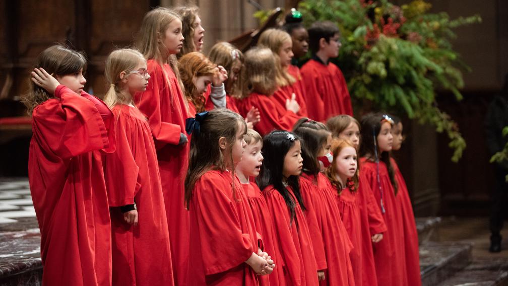 The children's choir in red choir robes singing in Trinity Church