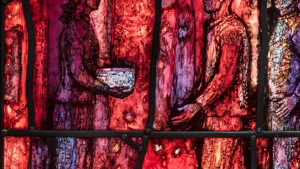 A close-up of the new stained-glass window at Trinity Church showing a person serving others from a bowl in their hands