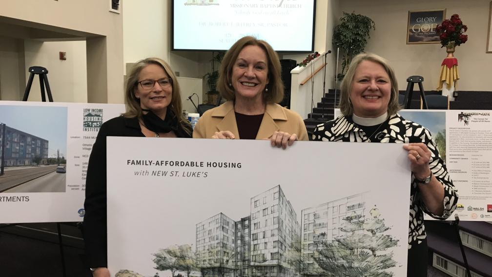 Members of St. Luke’s Episcopal Church hold the rendering of the new buildings that will be built on St. Luke’s property.