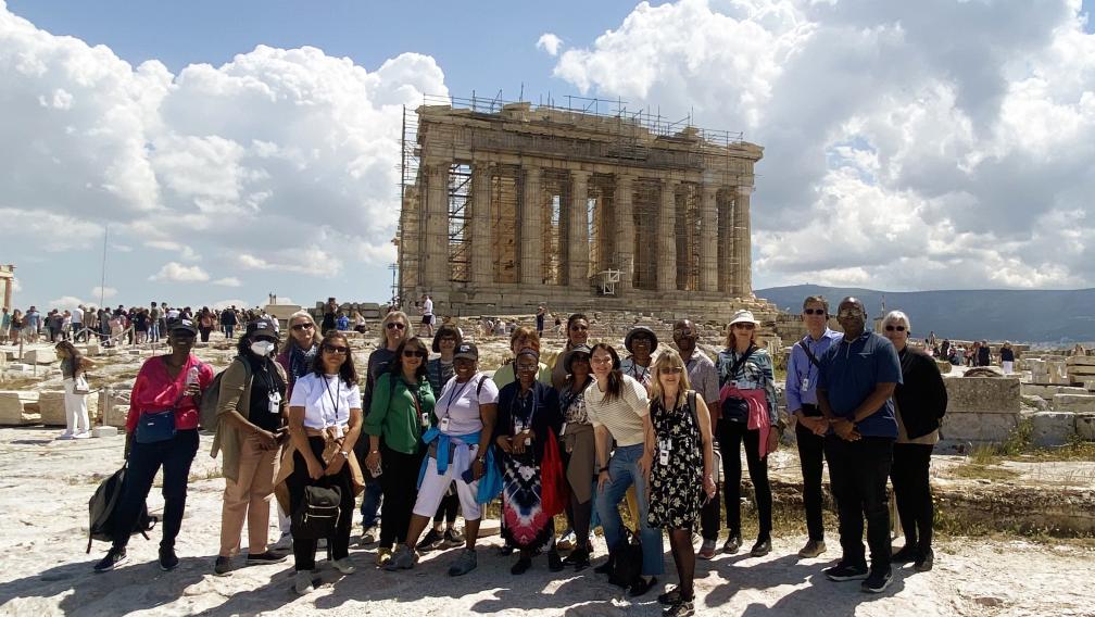 Group of people stand in front of ancient temple