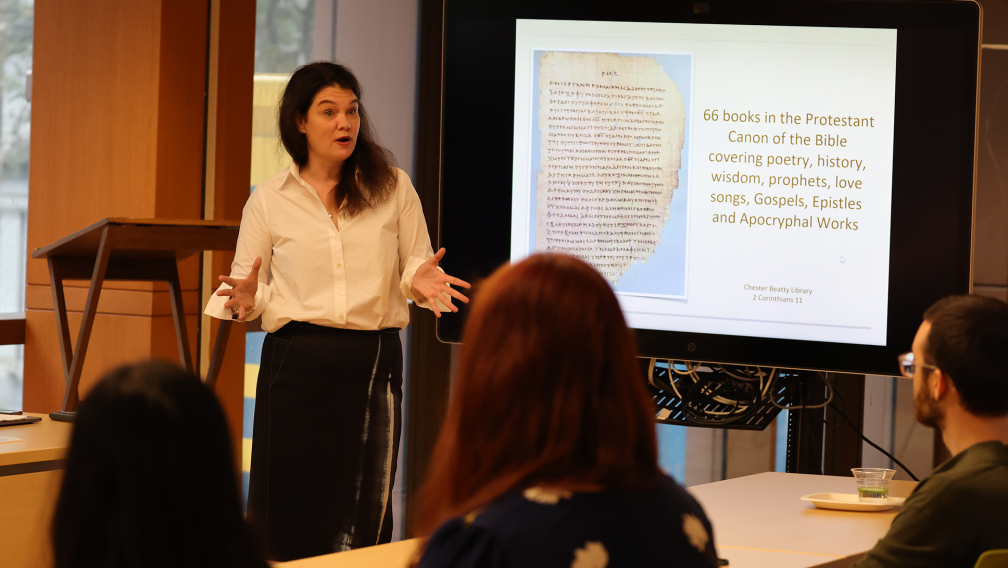 Summerlee Staten stands in front of a room of listening students at the Foundations course