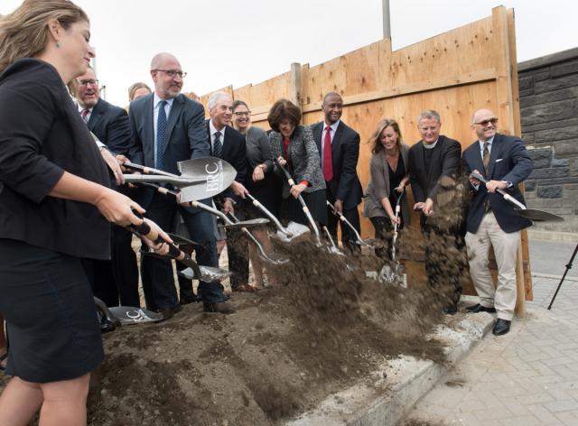 A group of people stand with shovels, throwing dirt at the BRC groundbreaking ceremony.