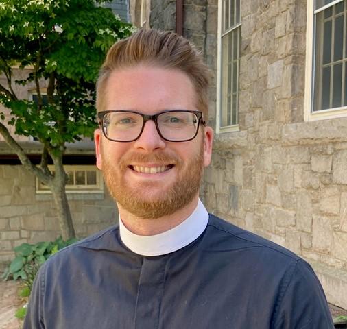 Jarred Mercer smiles directly at the camera, wearing glasses and a clergy collar.