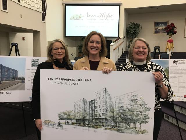 Members of St. Luke’s Episcopal Church hold the rendering of the new buildings that will be built on St. Luke’s property.