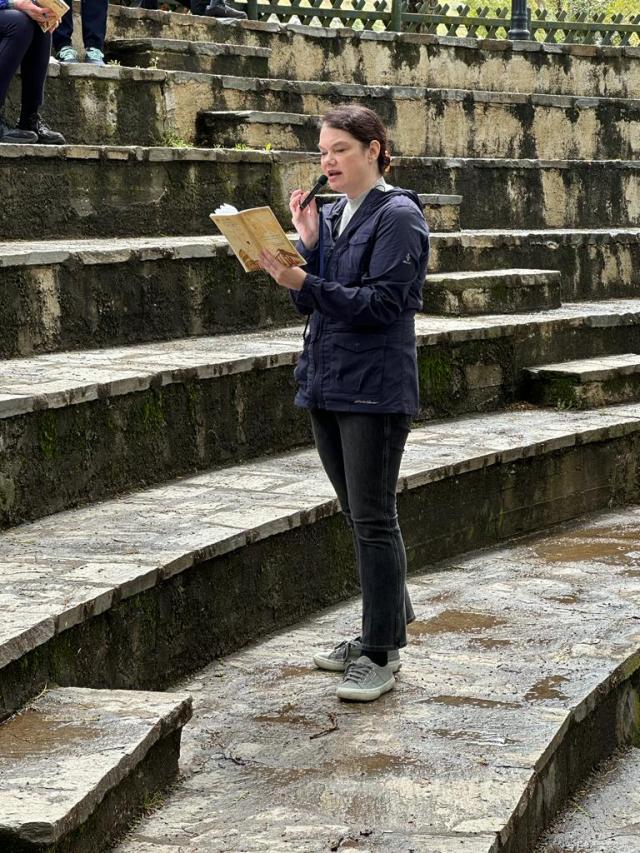 woman with book in hands speaks