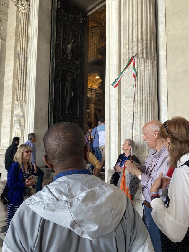 Group of people stand in front of large doors