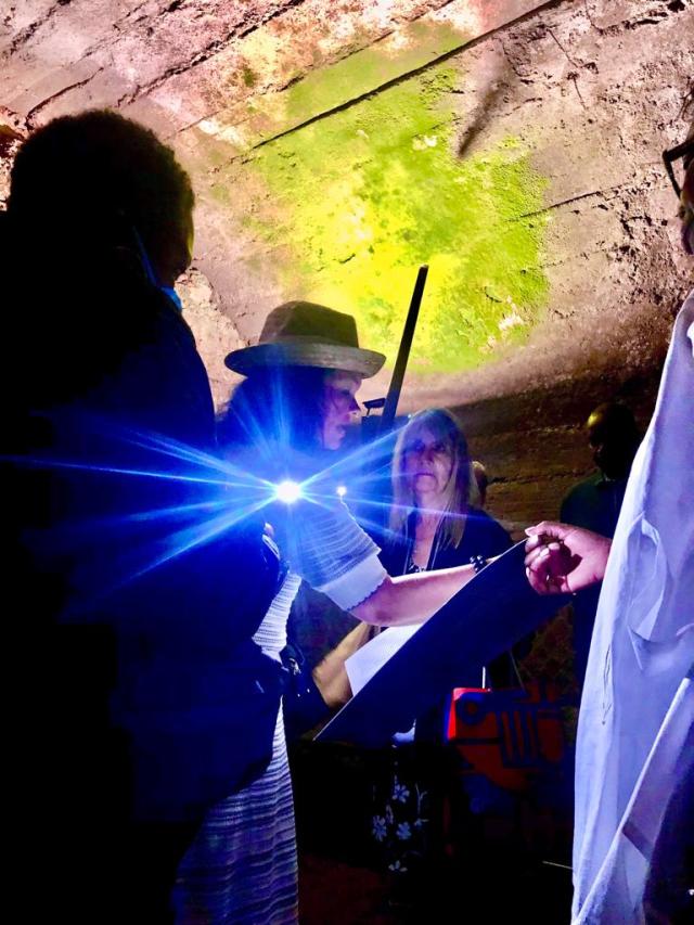 People looking at ceiling of underground cave