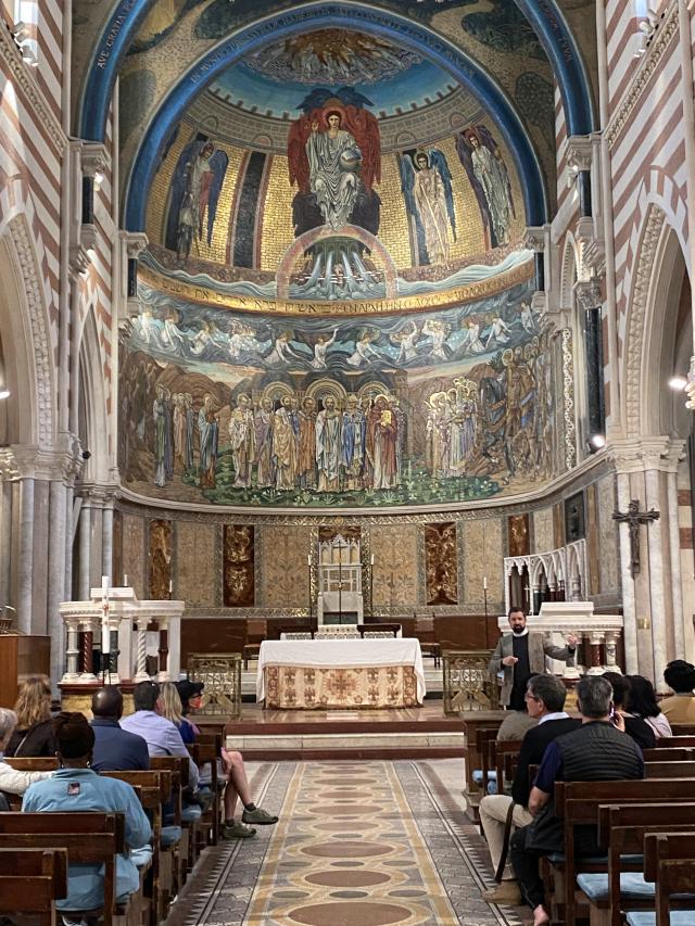 Man stands in front of congregation sitting inside church