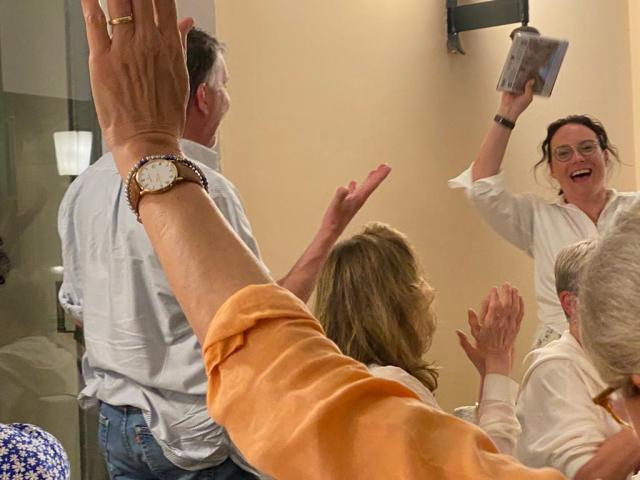 Smiling people with hands raised