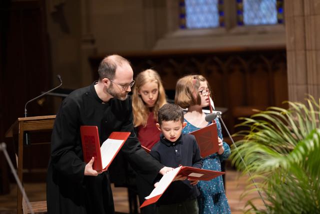 Dane Miller providing young parishioners with reading instructions on Palm Sunday