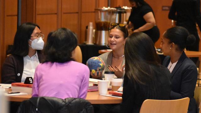 Racial Justice initiative grantees connect in restorative circles, with one participant speaking animatedly with a soft globe in her hand.  