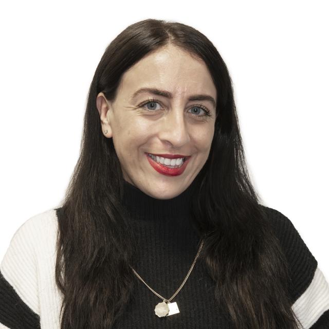 Barbara DiGangi wears a black and white top, wearing red lipstick.