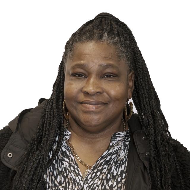 Mary Cannon smiles wearing a black coat and monochrome abstract top.