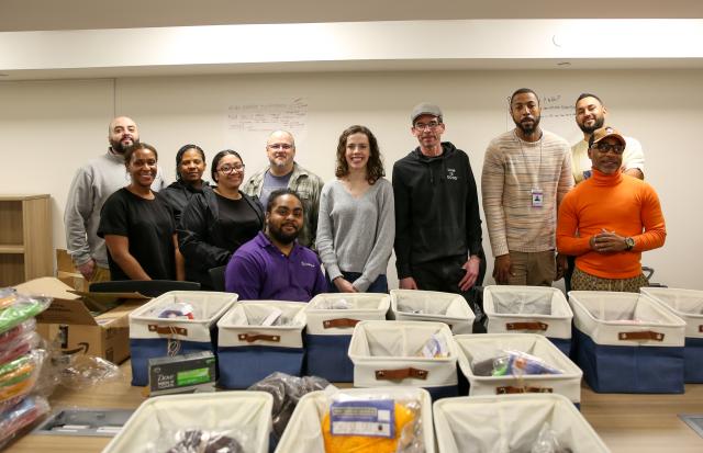 Seán Dalpiaz (back row, third from right) and other Osborne Association staff prepare welcome baskets for Fulton Center residents.