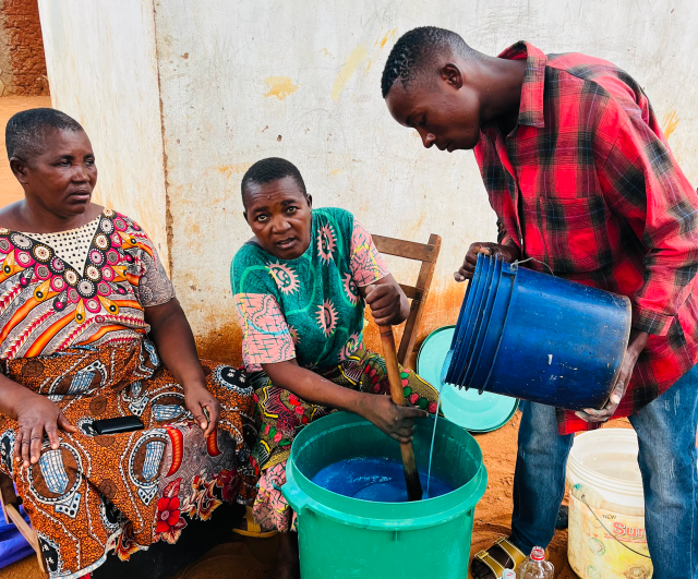 A few representatives from a Savings with Education group in Tanzania mix and stir ingredients to prepare liquid soap at one of the members' household. Photo credit: Diocese of Central Tanganyika - Development Services Coordination staff