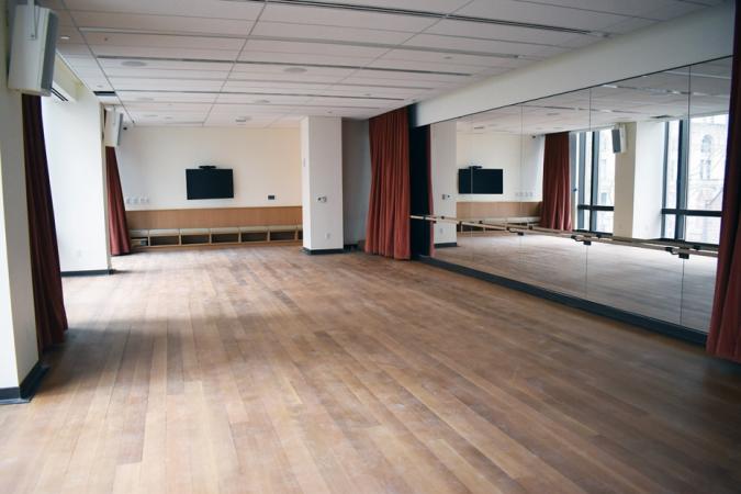 View of a the wall-length mirror and barre in the Rehearsal Studio