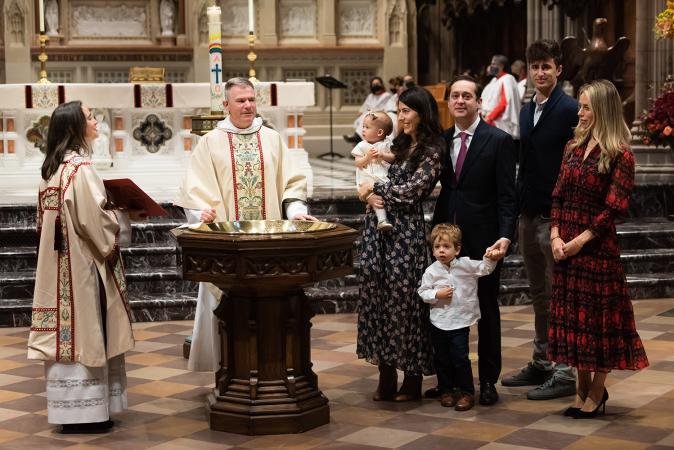 A child is baptized in Trinity Church on All Saints Sunday 2021