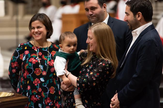 A child is baptized in Trinity Church on All Saints Sunday 2021