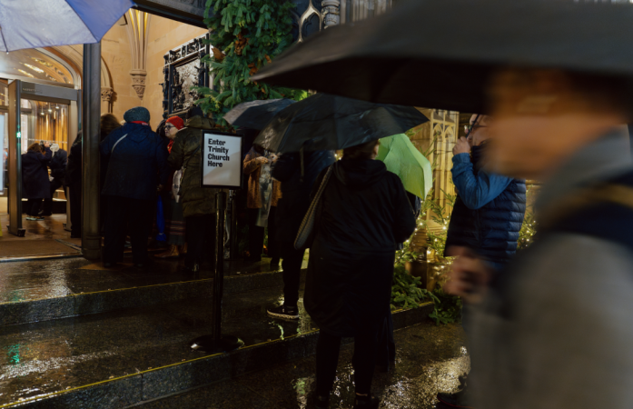 Concert-goers wait to enter Trinity Church in the rain.
