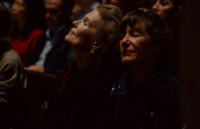 Audience members listen with eyes closed