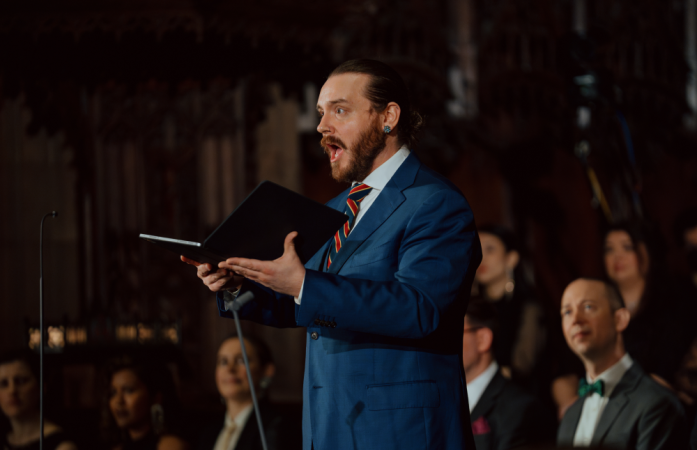 Male soloist in a blue suit sings passionately.