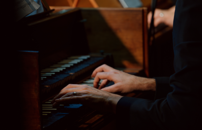 Close-up of hands playing a harpsichord