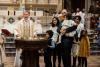 A child is baptized in Trinity Church on All Saints Sunday 2021