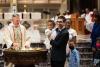 A child is baptized in Trinity Church on All Saints Sunday 2021