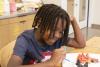A boy paints a sculpture during the 2023 Children's Summer Program