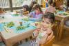 A girl holds up pieces of broccoli during a cooking class in the Trinity Commons kitchen