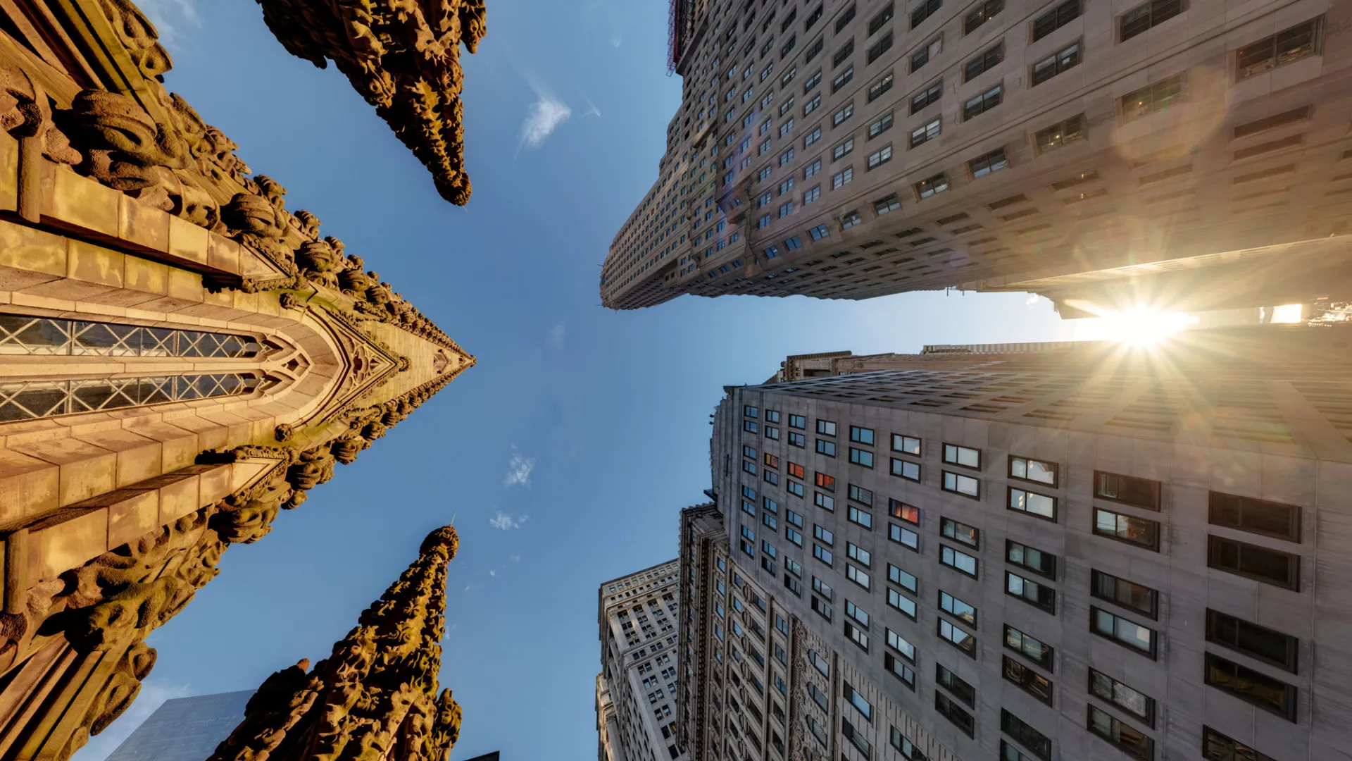 Sunrise in Downtown Manhattan, looking up to the top of Trinity's steeple and the tops of other buildings