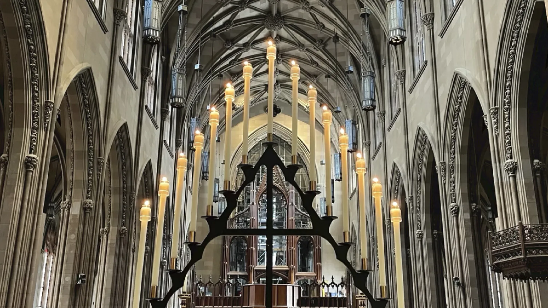 Tenebrae hearse candleholder arranged in a triangle, with 15 taper candles and the nave of Trinity Church in the background.