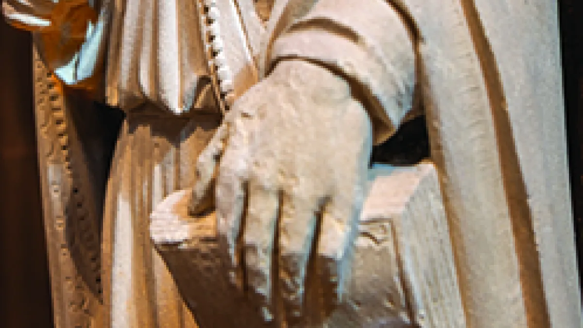 Detail of sculpture; hand holding book