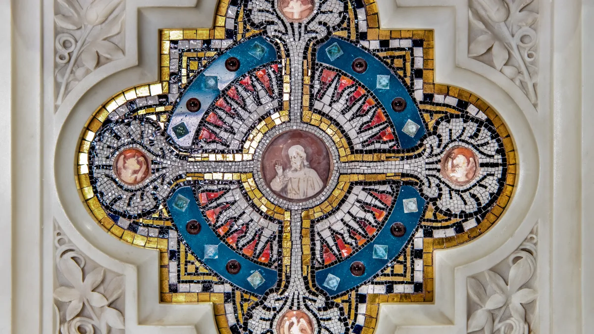Close-up square image of blue and yellow mosaic in the altar with Jesus and four circles around him.