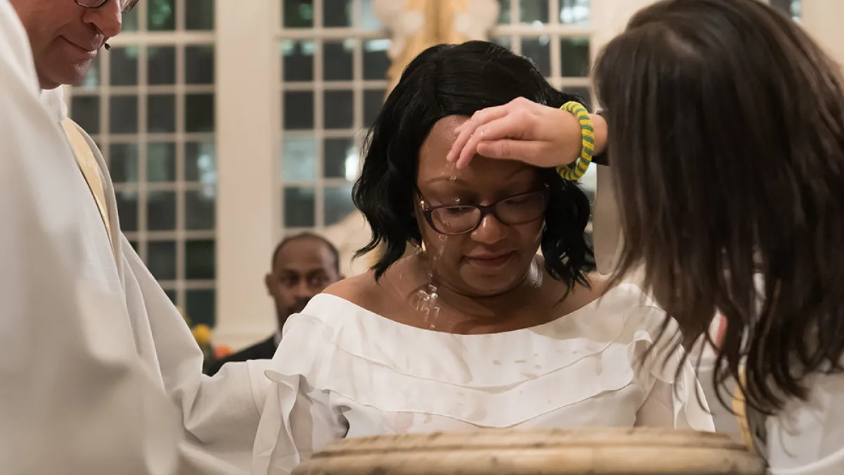Priest baptizing woman
