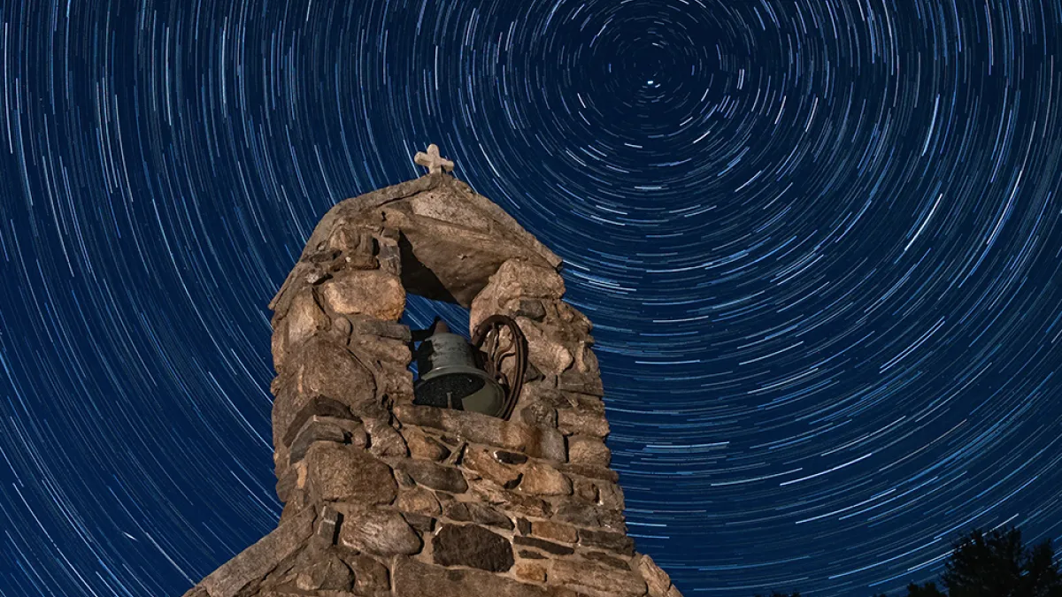 A long exposure image of a star-filled sky above the chapel at Trinity Retreat Center