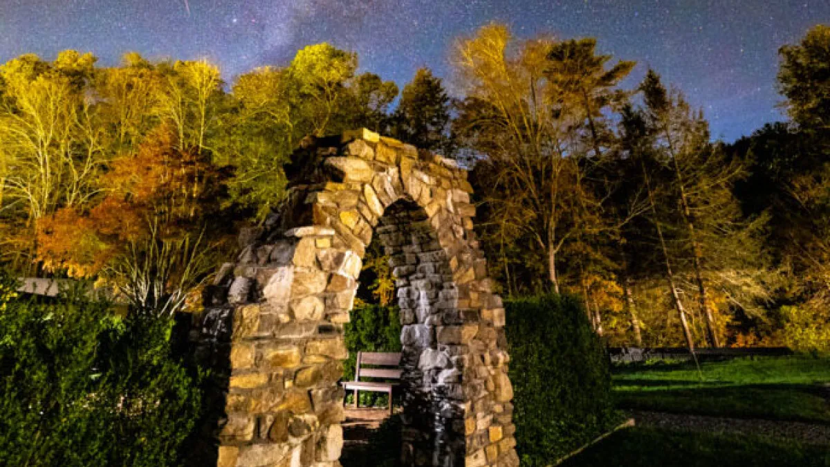 Stone arch under a brilliant night sky