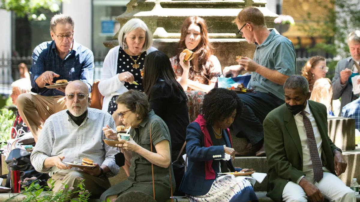 A group of parishioners enjoy lunch on the steps of the Soldiers' Monument in the northeast corner of Trinity Churchyard during a Spring 2022 Celebration.